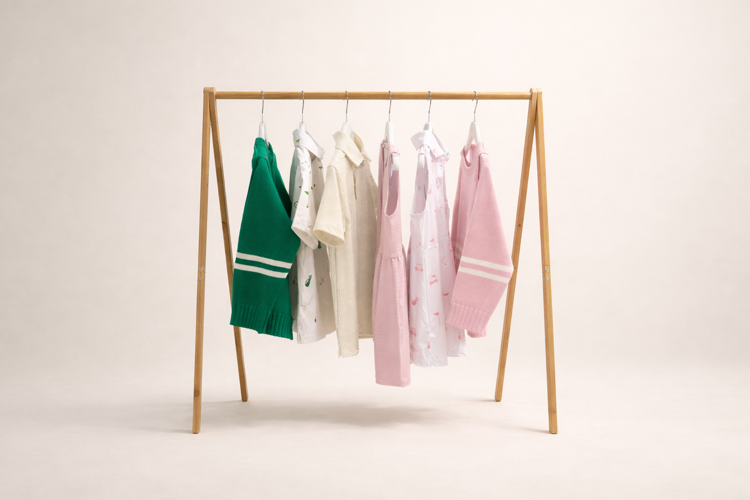 Clothing rack with colorful children's garments on a plain background